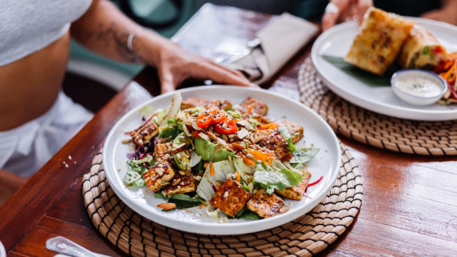 woman-having-colorful-healthy-vegan-vegetarian-meal-salad-summer-cafe-natural-day-light-660x372